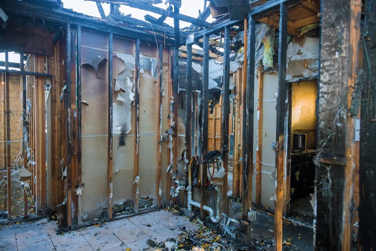 Fire-damaged interior of a home with charred wall framing
